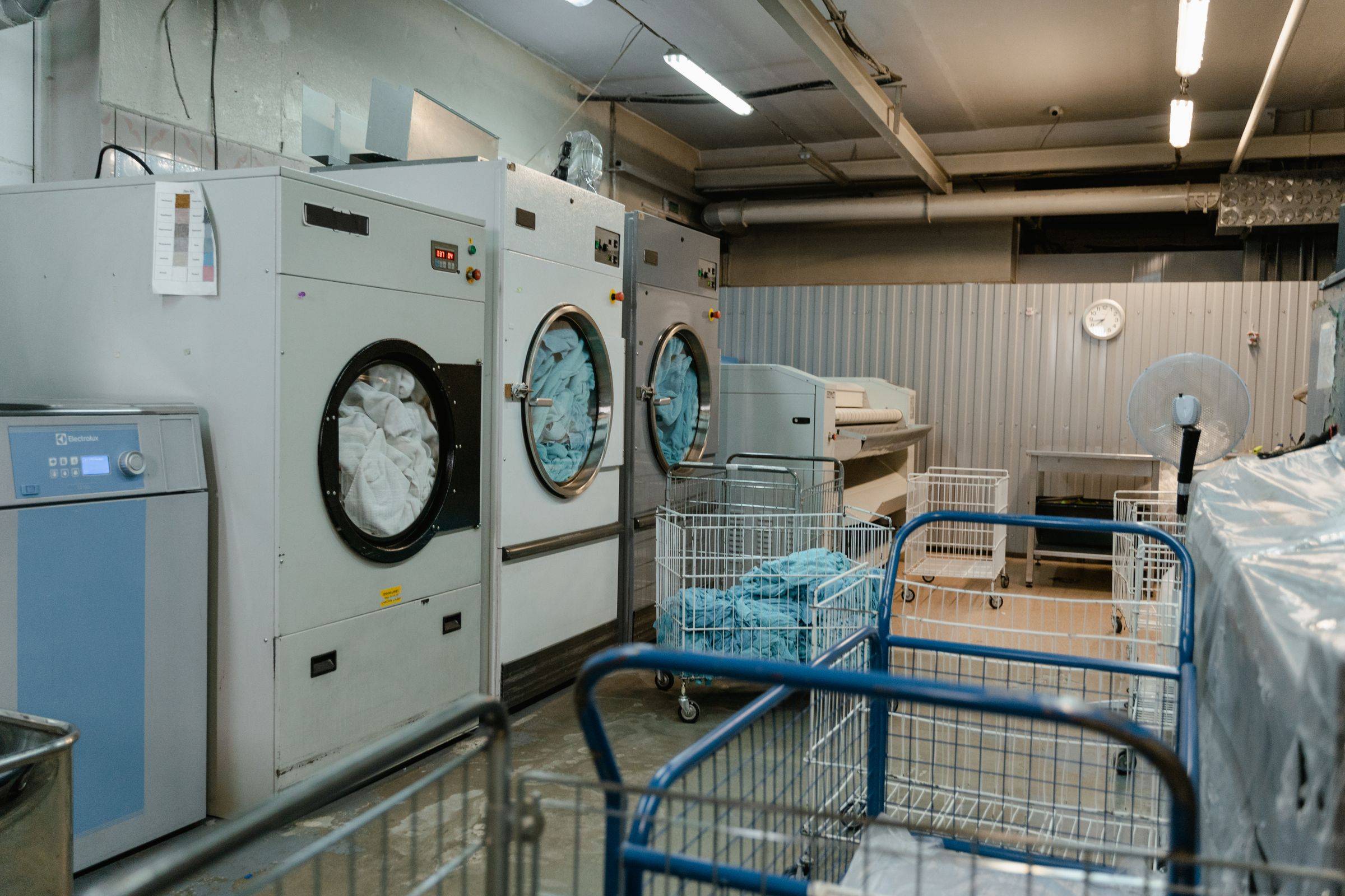 Machines à laver industrielles et chariots de linge dans une blanchisserie